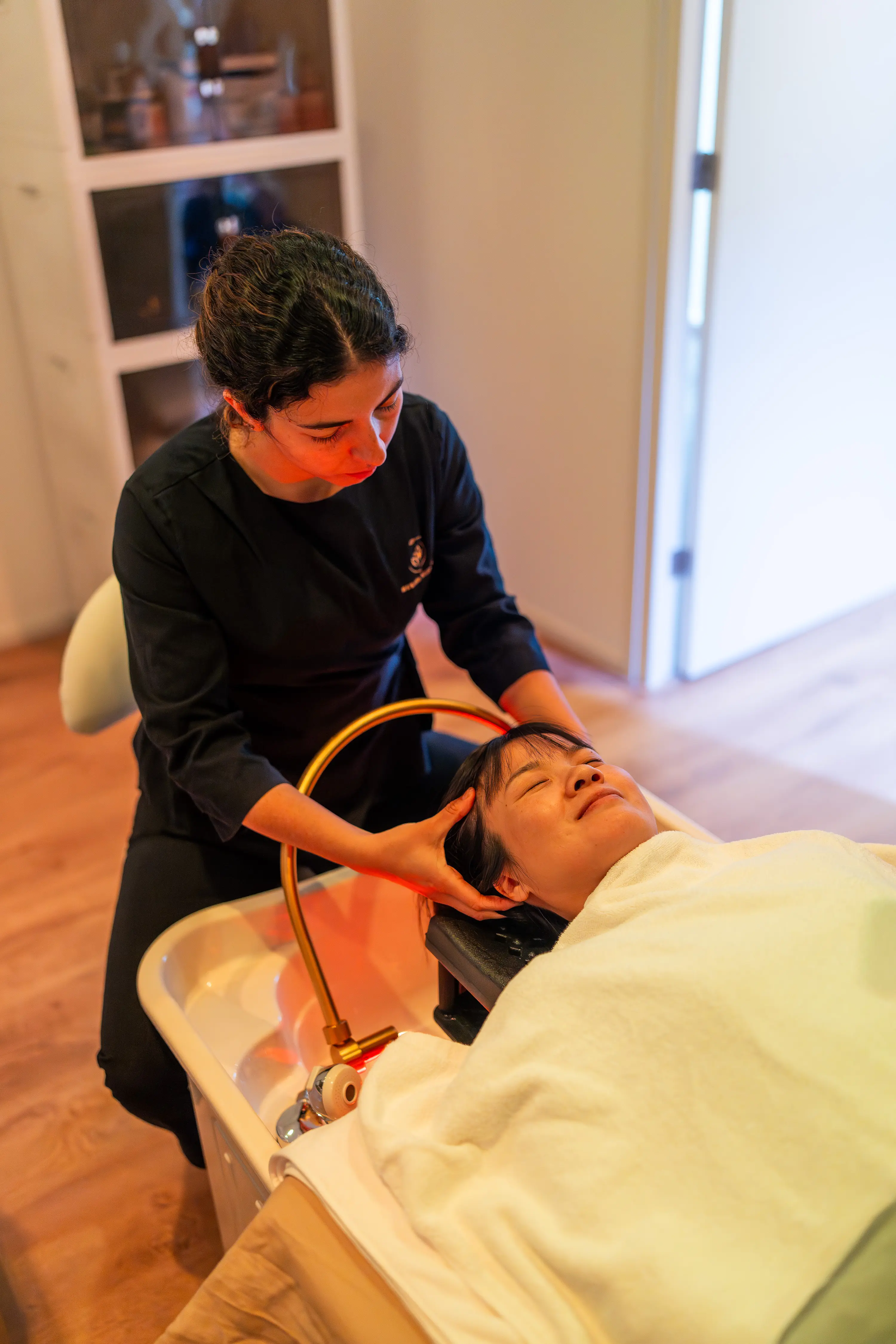 Shinsui Head Spa — therapeut behandelt hoofdhuid met warm licht